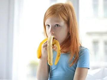Niña comiendo un plátano Niña comiendo un plátano