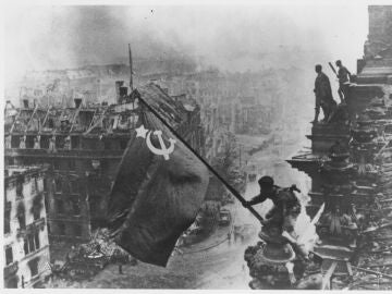 Soldados rusos ondeando la Bandera Roja, hecha con manteles, sobre las ruinas del Reichstag en Berlín