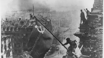 Soldados rusos ondeando la Bandera Roja, hecha con manteles, sobre las ruinas del Reichstag en Berlín