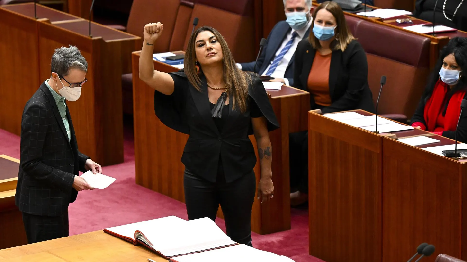 La senadora de los Verdes de Australia por Victoria, Lidia Thorpe, levanta el brazo durante su ceremonia de juramento en el Senado.