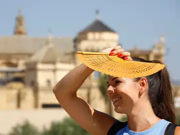 Una mujer se protege del sol con un abanico en Córdoba, ayer.