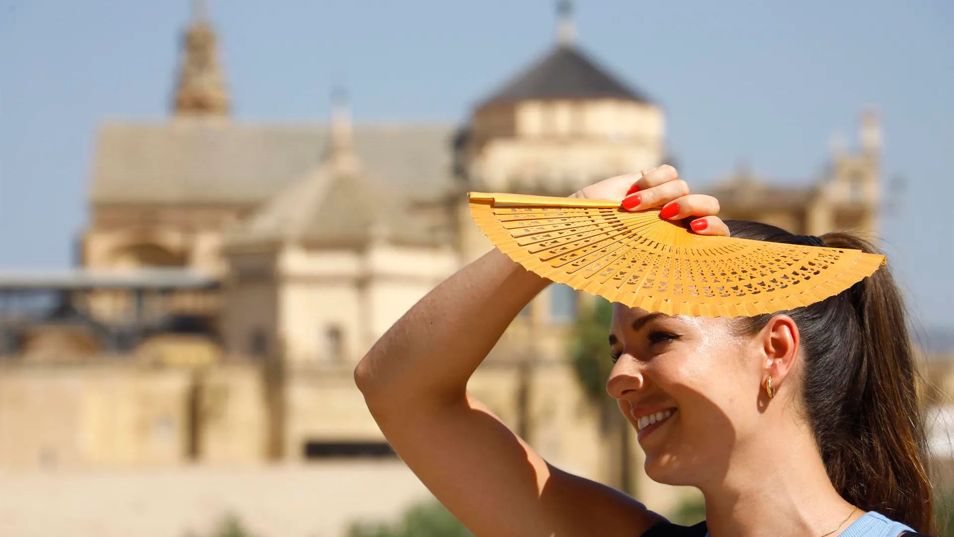 Una mujer se protege del sol con un abanico en Córdoba, ayer.