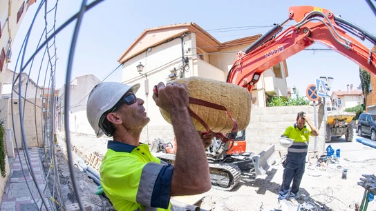 Un operario bebe agua en un descanso mientras realiza tareas de canalización de aguas en una calle de Granada Un operario bebe agua en un descanso mientras realiza tareas de canalización de aguas en una calle de Granada