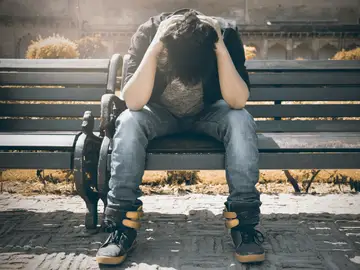 La estimulación de un área específica cerebral posible terapia para la depresión resistente al tratamiento Joven deprimido sentado en un banco del parque