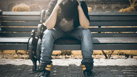 La estimulación de un área específica cerebral posible terapia para la depresión resistente al tratamiento Joven deprimido sentado en un banco del parque