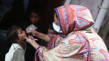 Una mujer suministra la vacuna contra la poliomelitis a un niño en Pakistán