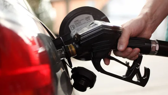 Un cliente echa gasolina en su vehículo Un cliente echa gasolina en su vehículo