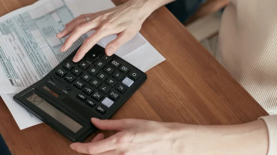 Una mujer usando la calculadora Así puedes evitar que la subida del euríbor afecte a tu hipoteca