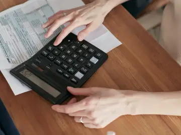 Una mujer usando la calculadora