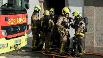 Un efectivo de bomberos durante las labores de extinción de un incendio en una vivienda de Santiago de Compostela.