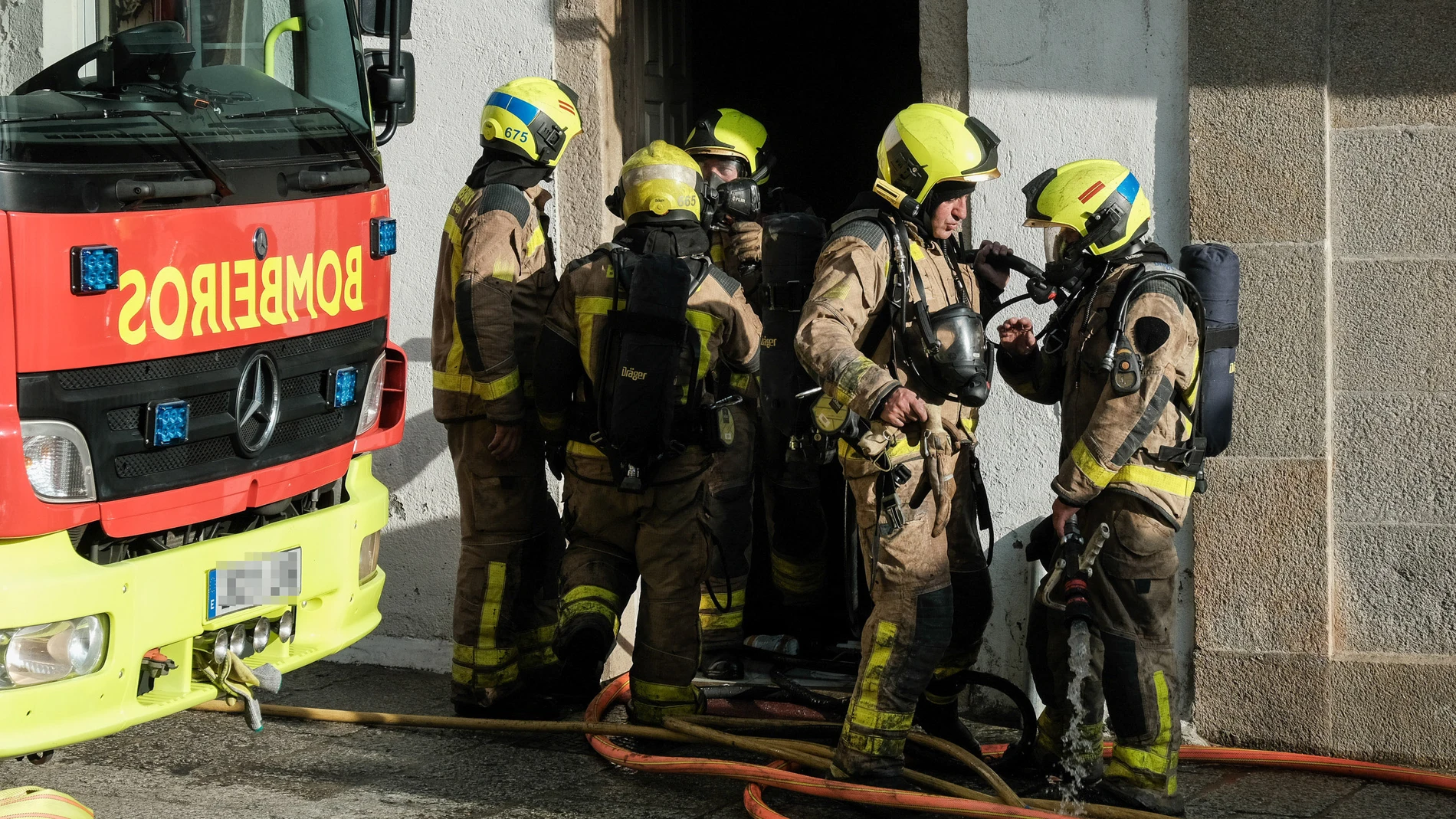 Un efectivo de bomberos durante las labores de extinción de un incendio en una vivienda de Santiago de Compostela.