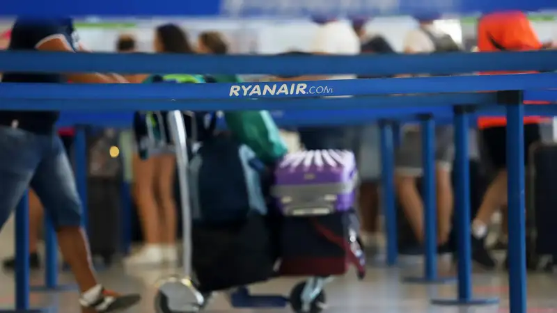 Turistas hacen colas en los puestos de embarque de Ryanair.