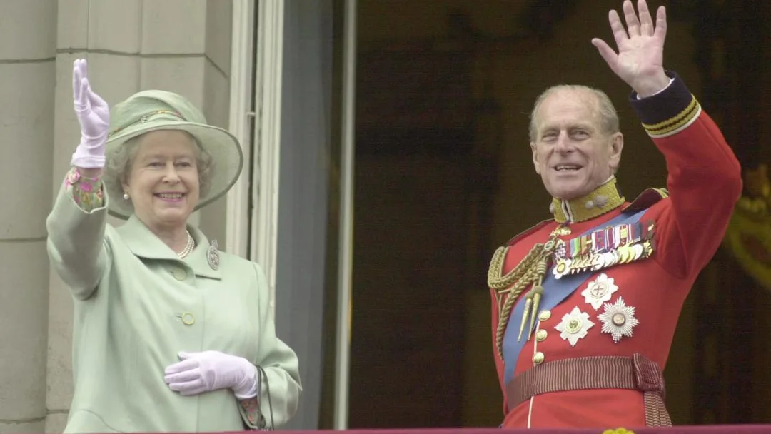 La reina Isabel II y el Duque de Edimburgo saludan desde el Palacio de Buckingham de Londres en junio de 2001