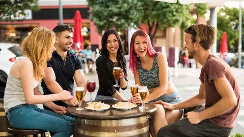 Grupo de jóvenes tomando cañas y tapas en una terraza Grupo de jóvenes tomando cañas y tapas en una terraza
