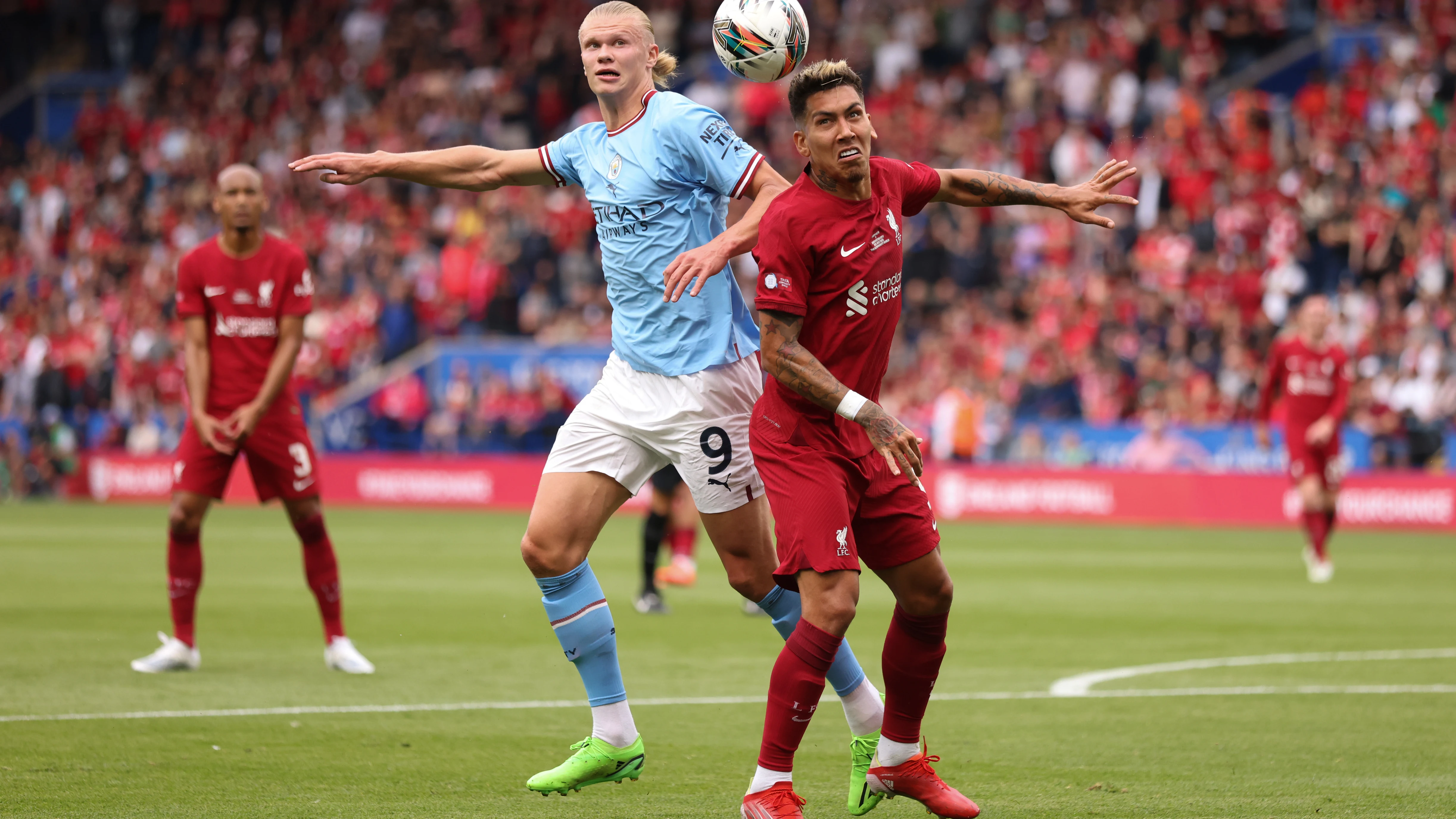 Haaland y Firmino disputan un balón