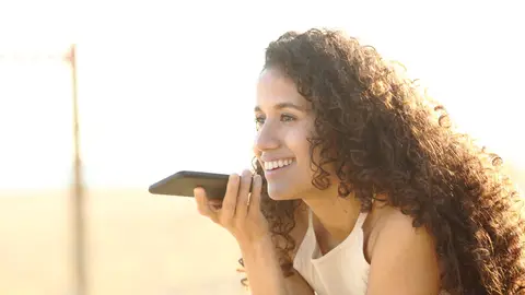 Mujer escuchando una nota de voz Mujer escuchando una nota de voz