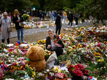 Una mujer deja unas flores en Green Park tras la muerte de Isabel II Una mujer deja unas flores en Green Park tras la muerte de Isabel II