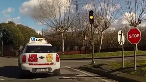 Una intersección con semáforo ambar y señal de Stop Una intersección con semáforo ambar y señal de Stop