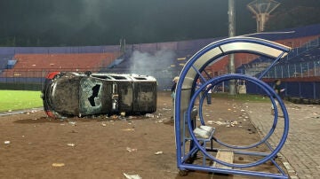 Un coche destrozado y volcado en el estadio Kanjuruhan de Indonesia, donde murieron al menos 125 personas
