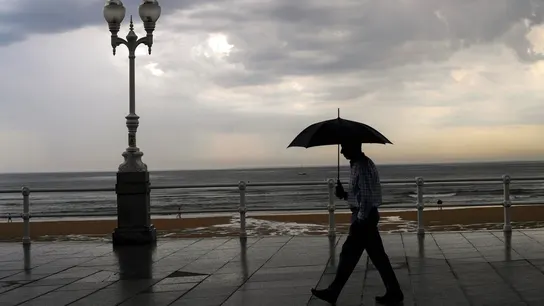 Un hombre se protege con el paraguas de la lluvia. Un hombre se protege con el paraguas de la lluvia.