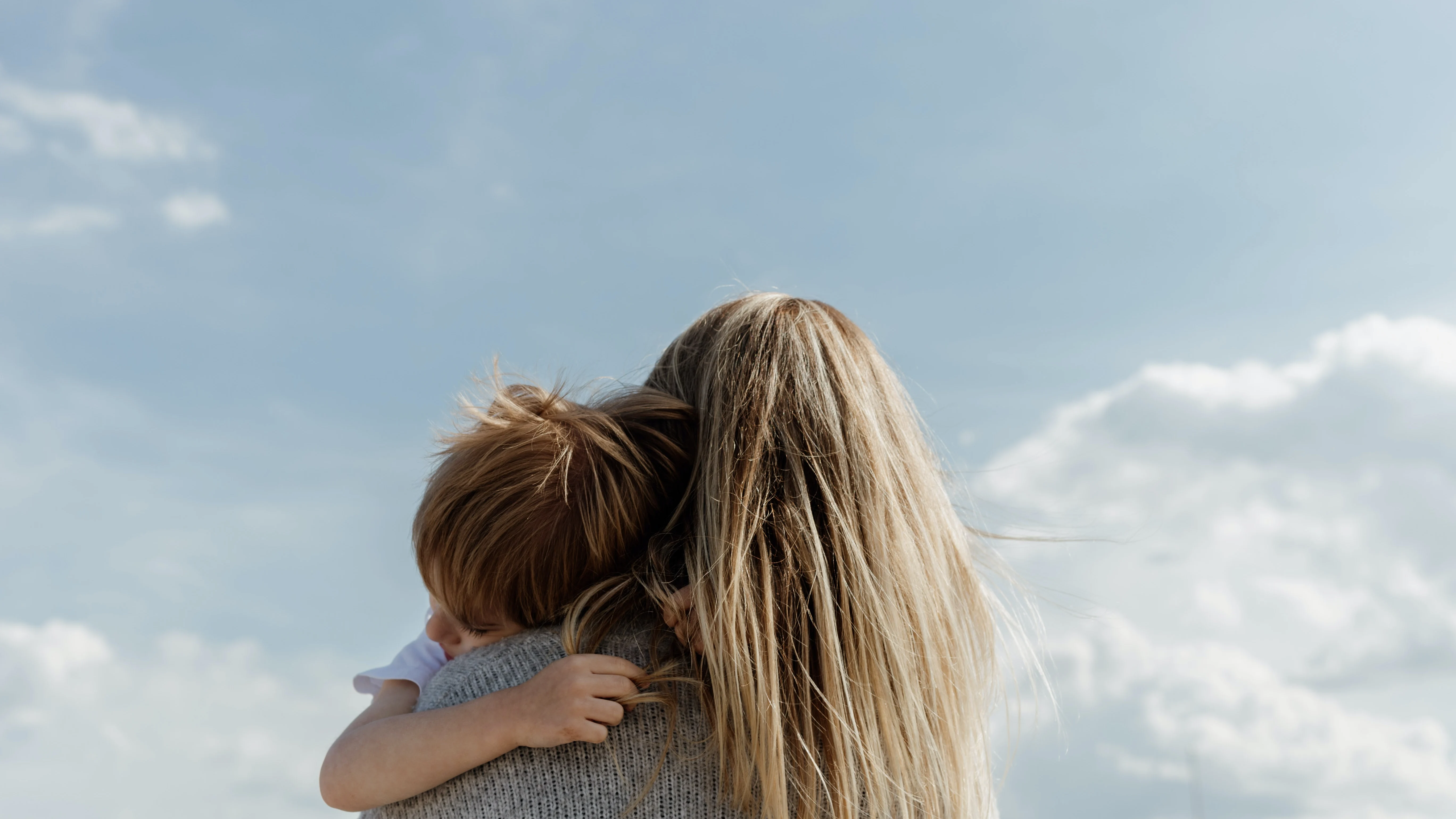 Imagen de archivo que muestra a una madre abrazando a su hijo/ Unsplash