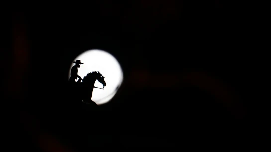 La figura de una veleta de un jinete delante de la silueta de la luna La figura de una veleta de un jinete delante de la silueta de la luna