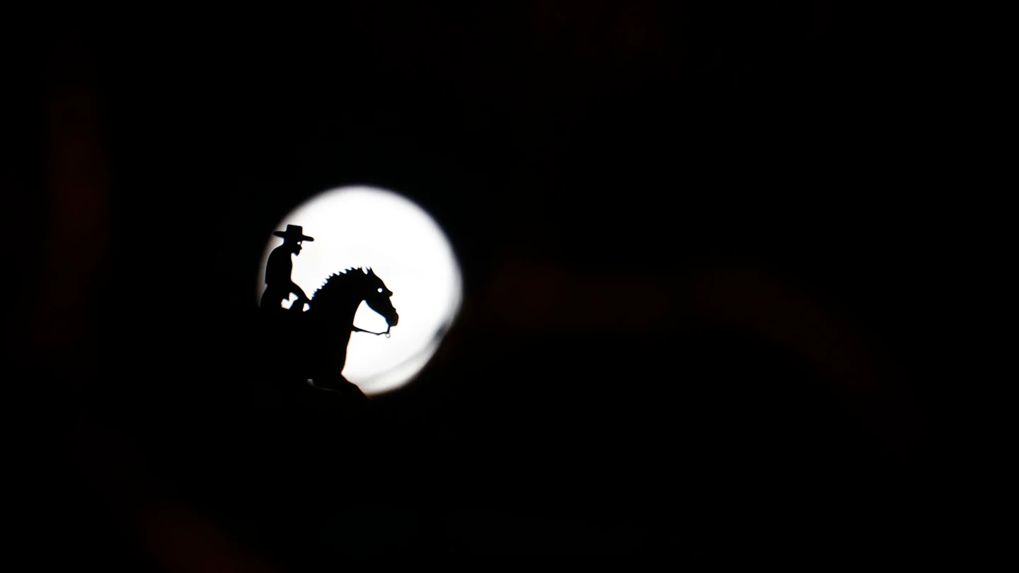 La figura de una veleta de un jinete delante de la silueta de la luna La figura de una veleta de un jinete delante de la silueta de la luna