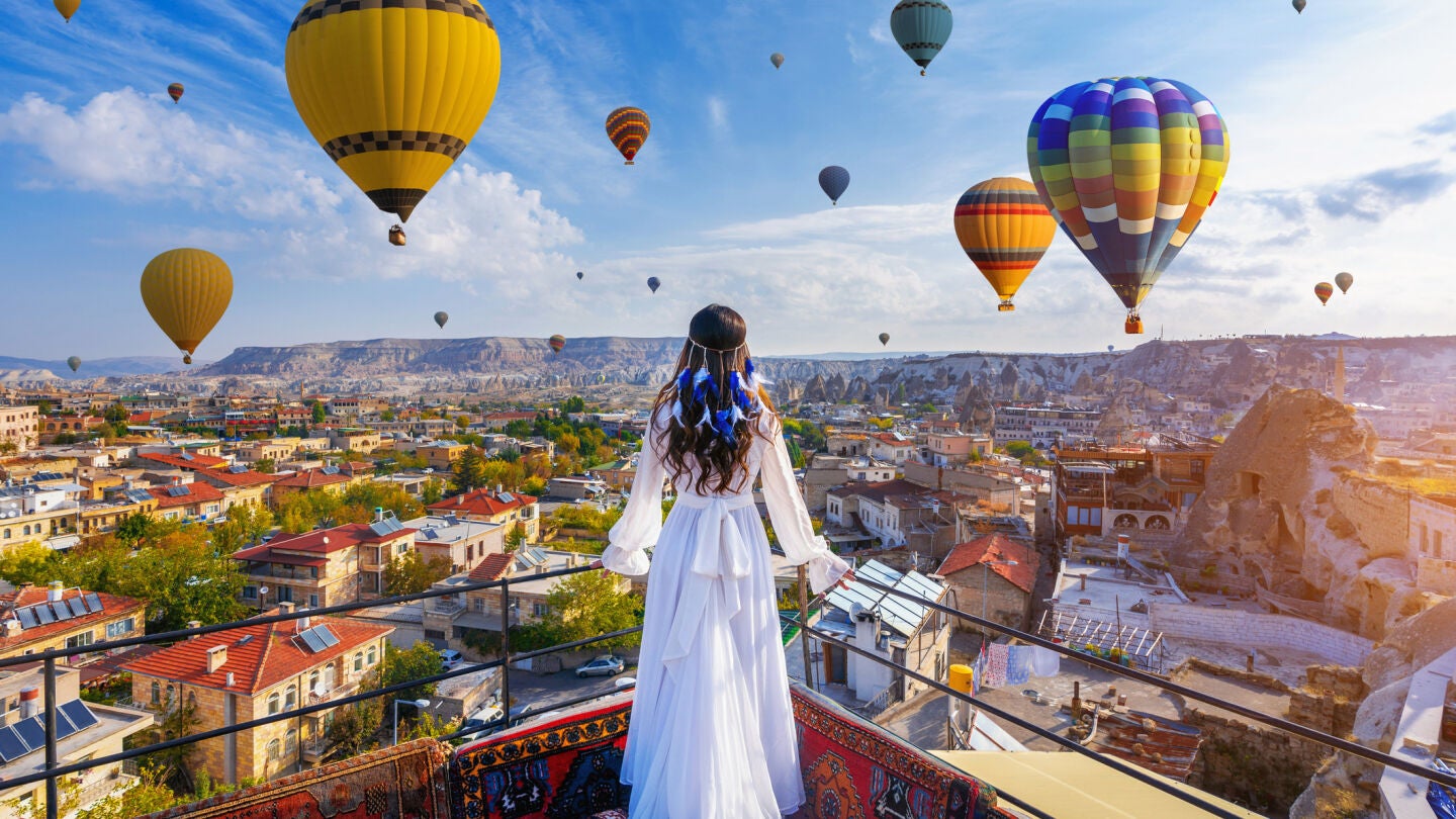 Mujer mirando los globos aerost&aacute;ticos en Capadocia, Turqu&iacute;a