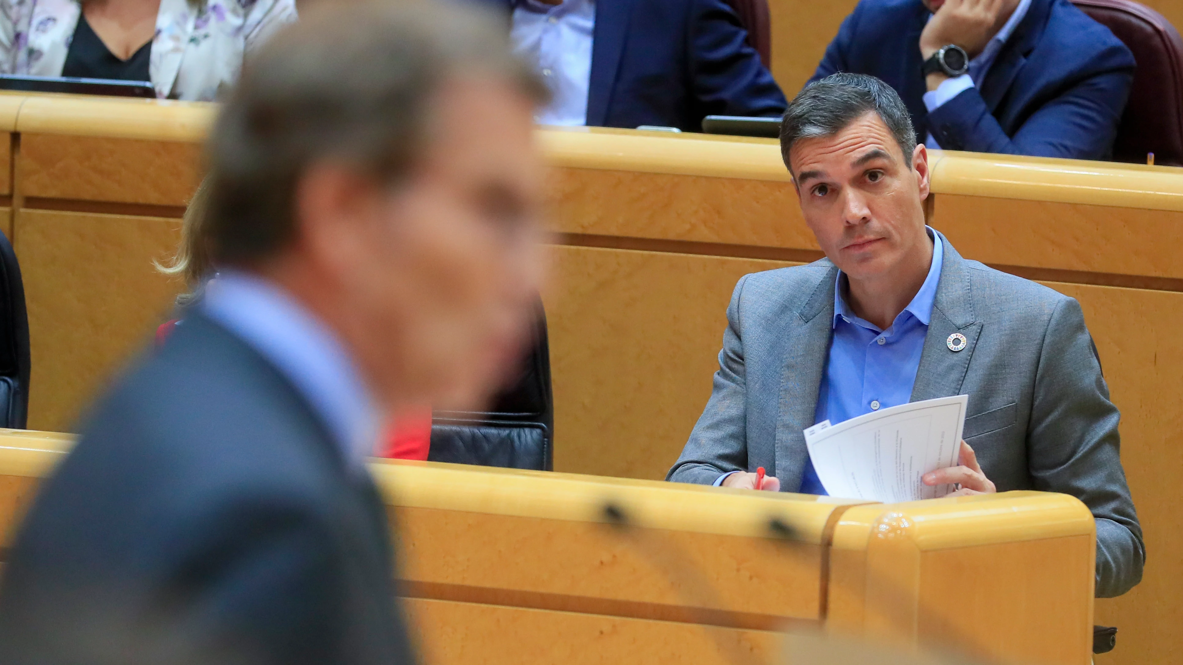 El presidente del Gobierno, Pedro Sánchez, escucha al líder del PP, Alberto Núñez Feijóo, en el Senado.