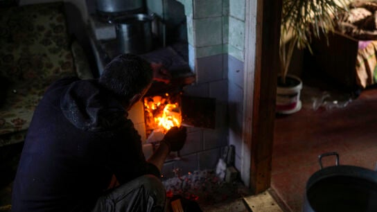Viktor Palyanitsa enciende le&ntilde;a en una estufa en su casa en Kurylivka, Ucrania, el domingo 16 de octubre de 2022. 