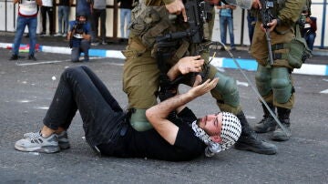 Soldados israelíes arrestan a un hombre palestino durante enfrentamientos tras una protesta en el centro de la ciudad de Hebrón, Cisjordania