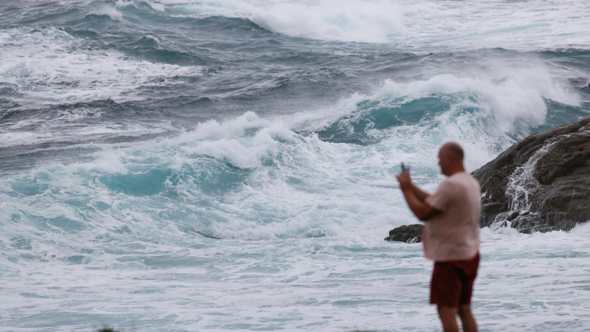 Un hombre hace una fotografía al oleaje durante un temporal