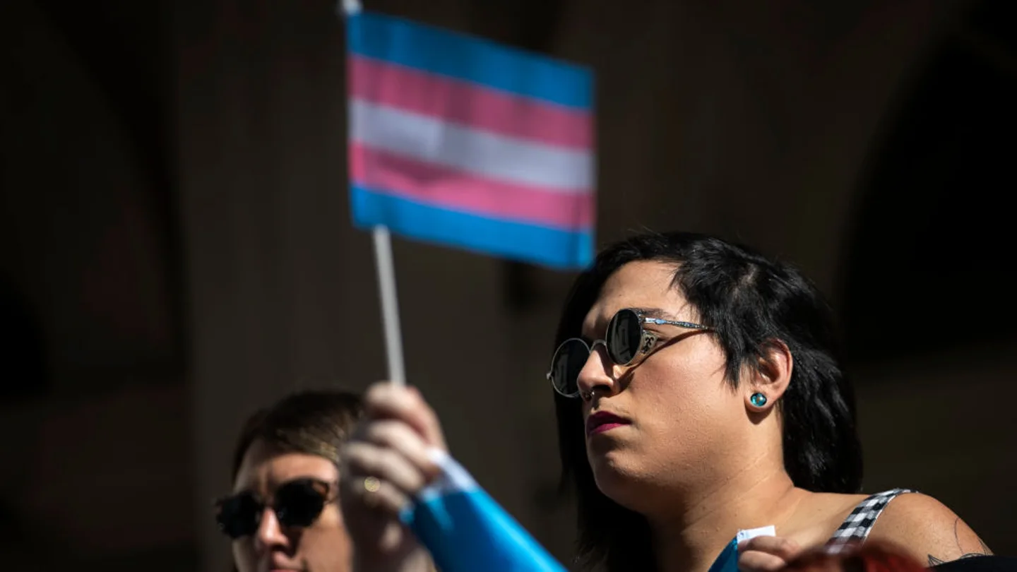 Imagen de archivo de una manifestante con la bandera trans Imagen de archivo de una manifestante con la bandera trans