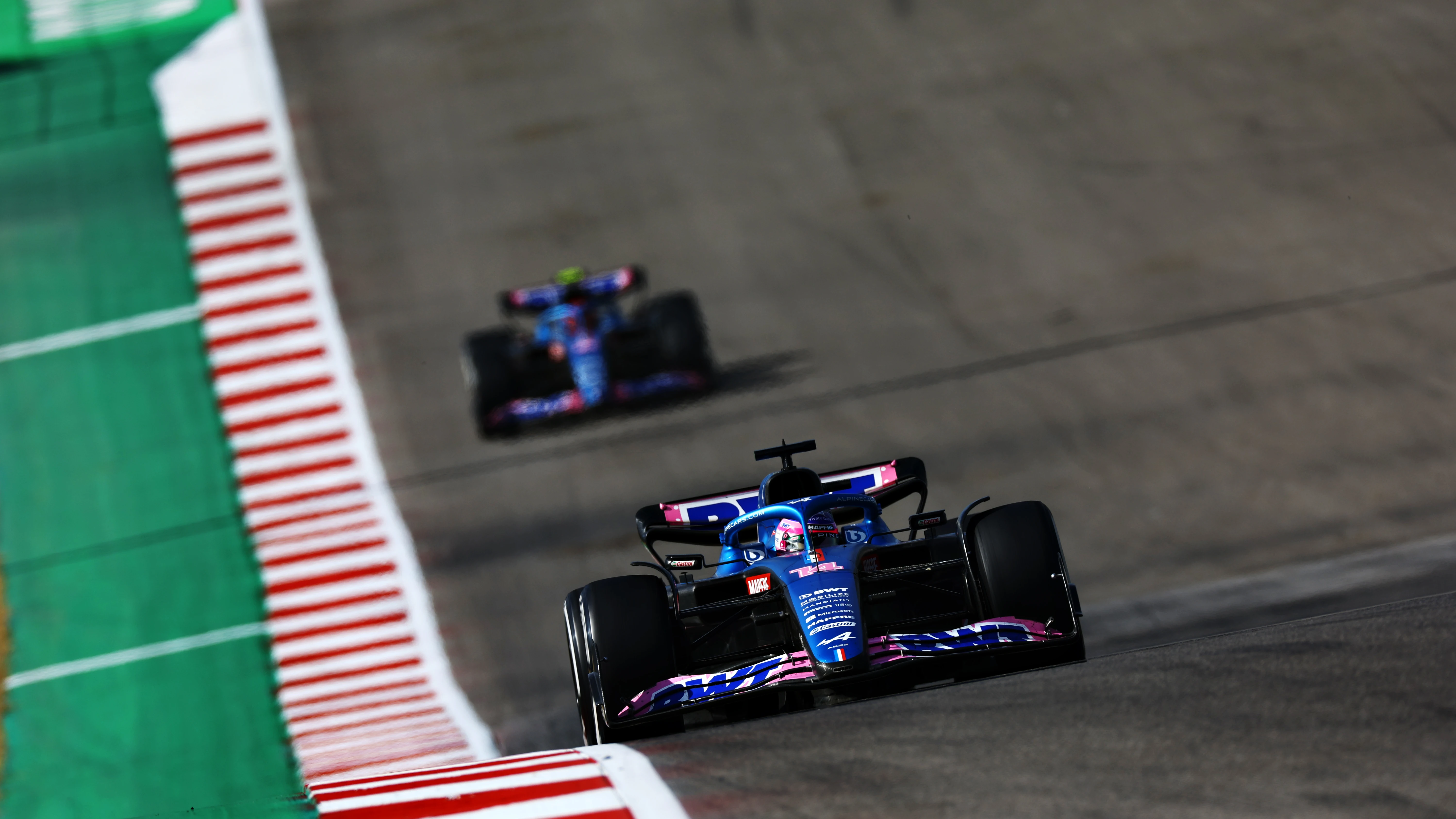 Fernando Alonso y al fondo, Esteban Ocon