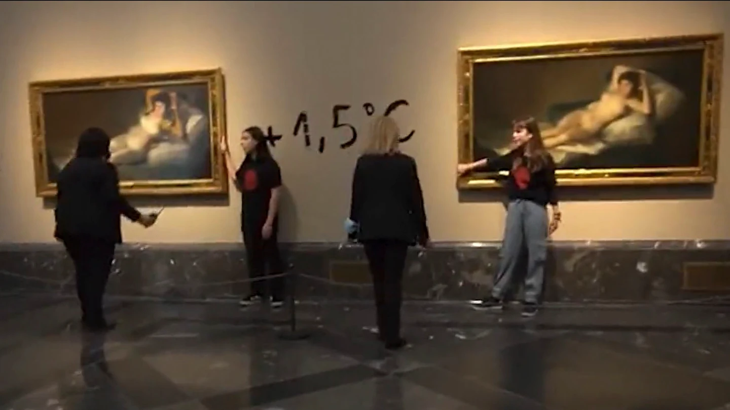 Momento en el que dos activistas se han pegado a los marcos de los cuadros de 'Las Majas' de Goya Momento en el que dos activistas se han pegado a los marcos de los cuadros de 'Las Majas' de Goya