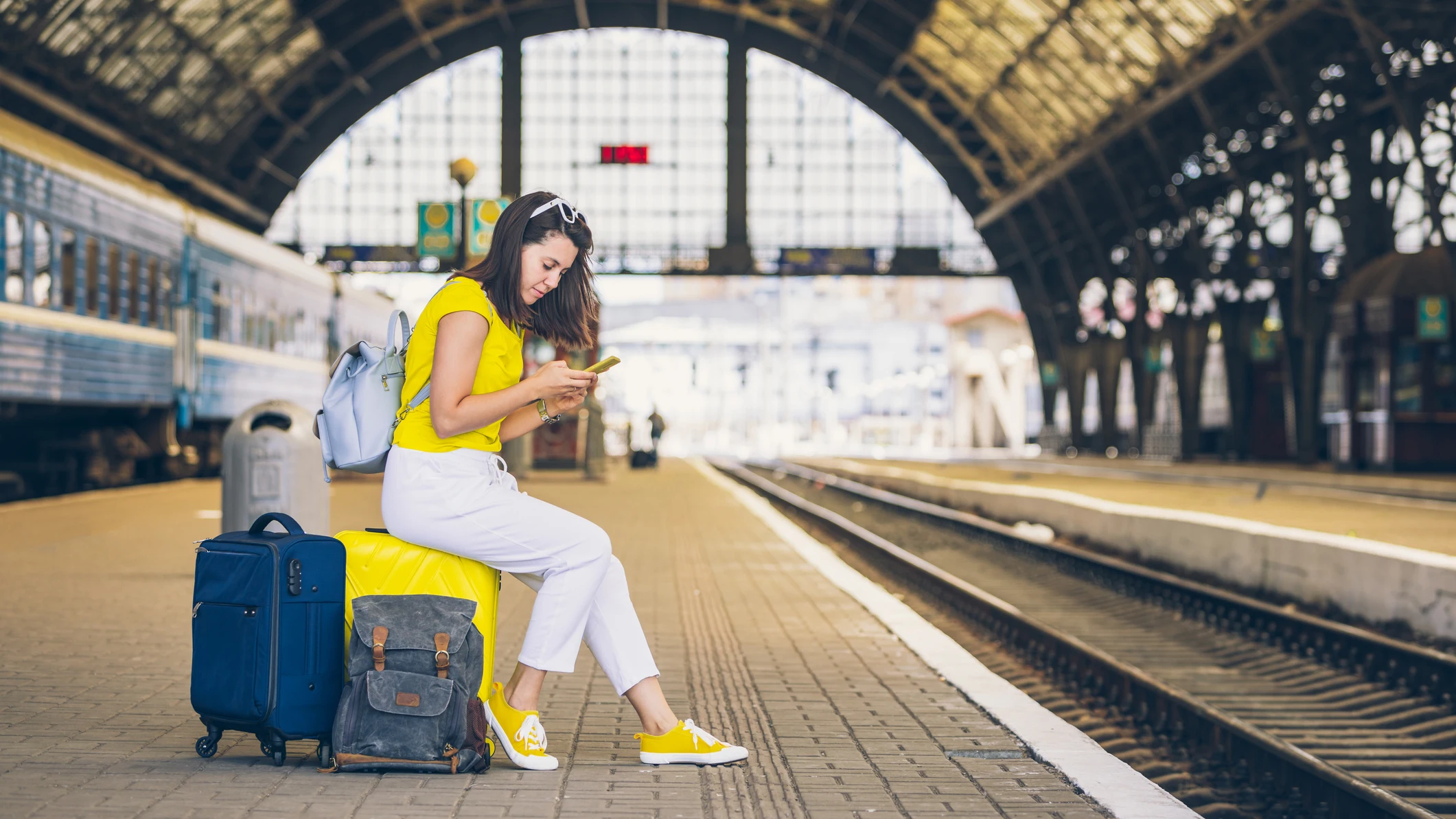 Chica esperando a su tren en la estaci&oacute;n