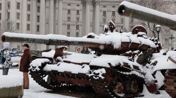 La gente mira los tanques rusos destruidos en la plaza Mykhailivs'ka (Kiev) mientras cae la nieve, a 19 de noviembre de 2022.