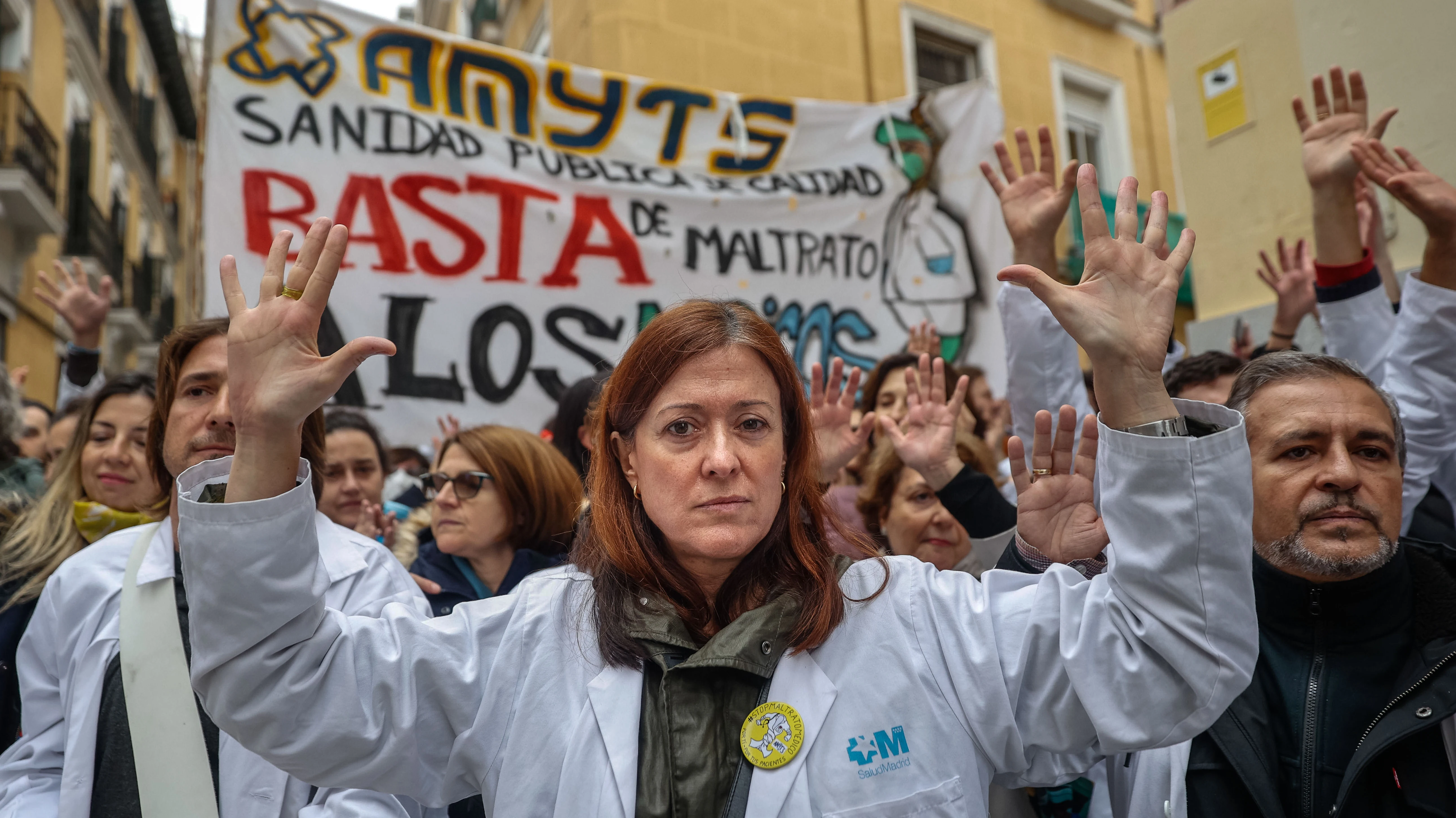 Varias personas grita al paso del tour de la precariedad que miembros del sindicato Amyts