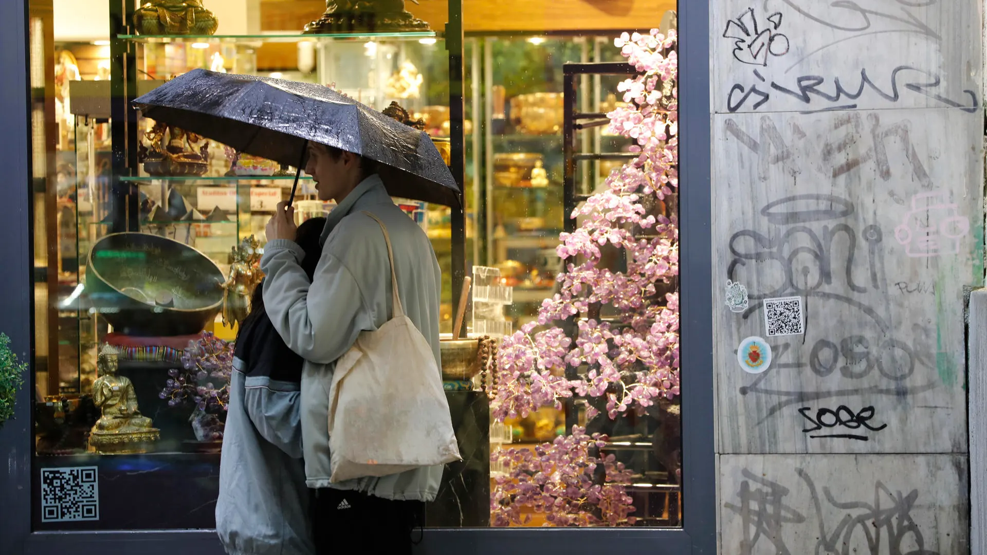 Dos jóvenes se protegen de la lluvia