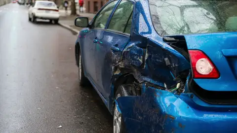 Coche golpeado por el lateral trasero Coche azul abollado por la zona del maletero
