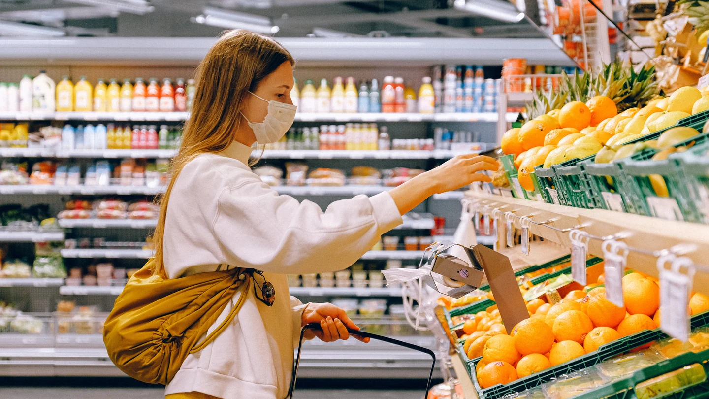 Una mujer mira los precios en el estante de un supermercado supermercado