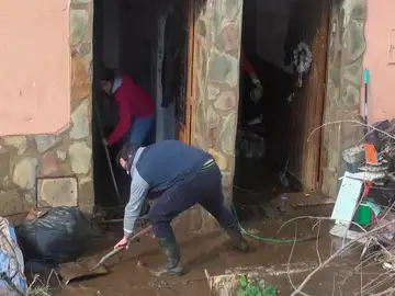 Vecinos de la localidad pacense de La Roca de la Sierra, uno de los municipios extremeños más afectados por las intensas lluvias, retiran el agua y el barro que ha anegado sus casas.