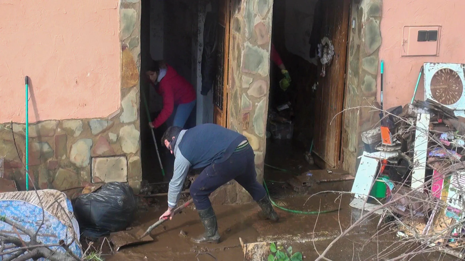 Vecinos de la localidad pacense de La Roca de la Sierra, uno de los municipios extremeños más afectados por las intensas lluvias, retiran el agua y el barro que ha anegado sus casas.