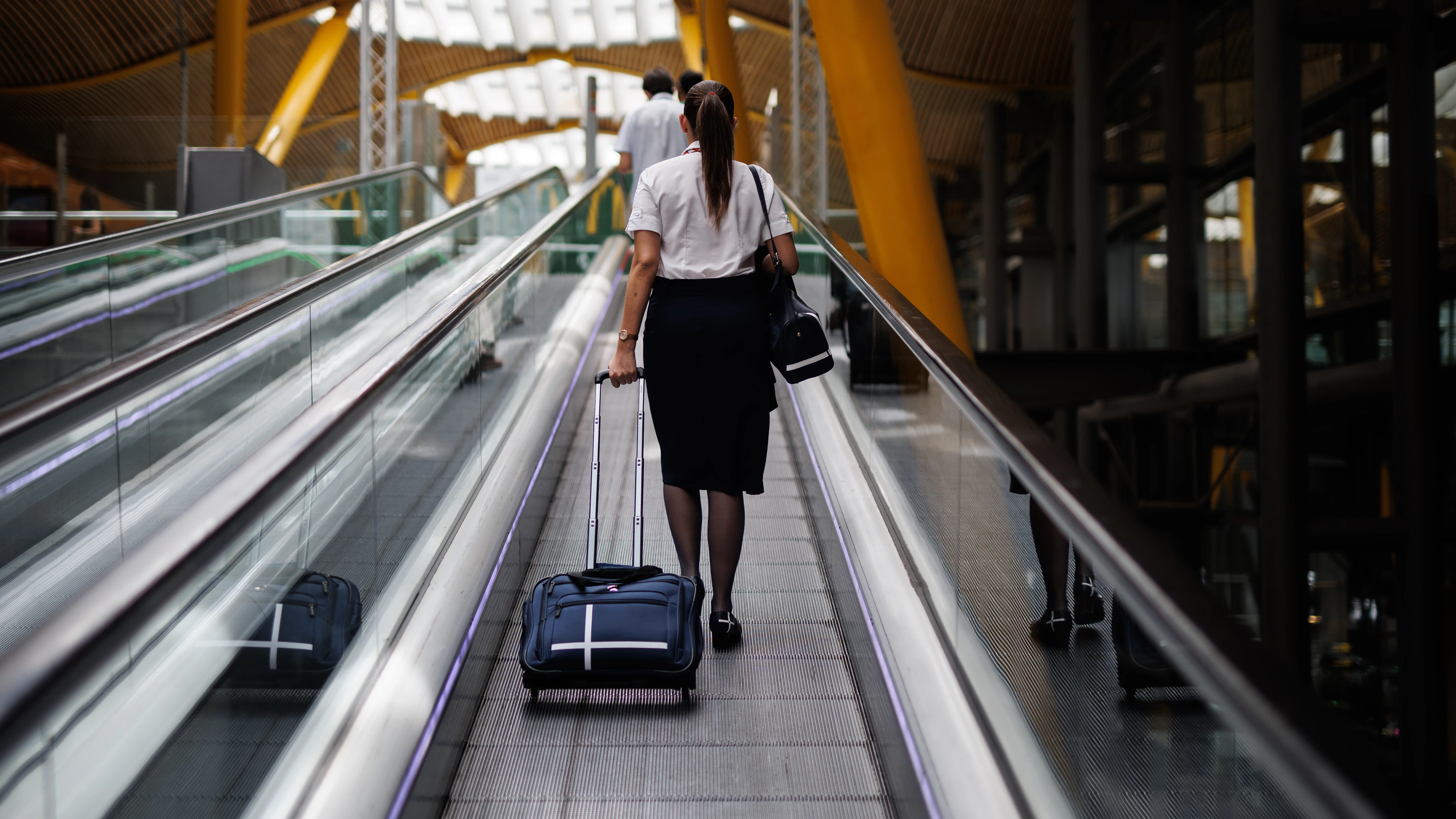 Imagen de archivo de una azafata de vuelo en las escaleras mecánicas de la Terminal 4 (T4) del aeropuerto Adolfo Suárez Madrid-Barajas.