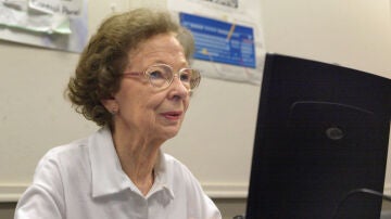 Una mujer de edad avanzada trabajando con un ordenador