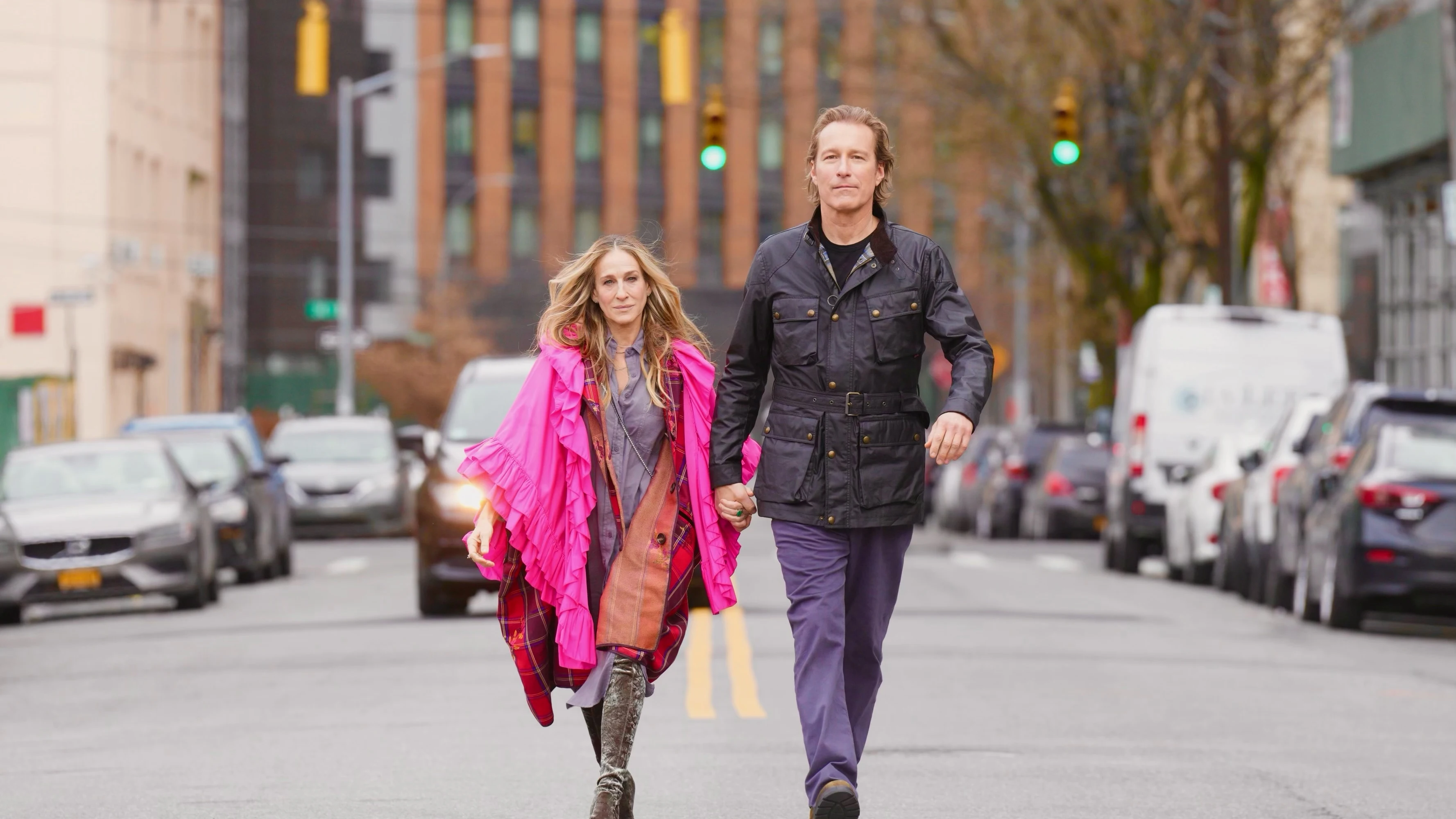 Carrie Bradshaw (Sarah Jessica Parker) y Aidan Shaw (John Corbett) pasean de la mano en una escena de 'And just like that' T2.