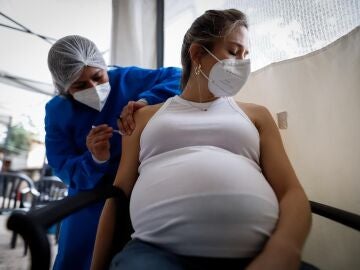 Personal médico aplica una dosis de la vacuna Moderna a una mujer embarazada