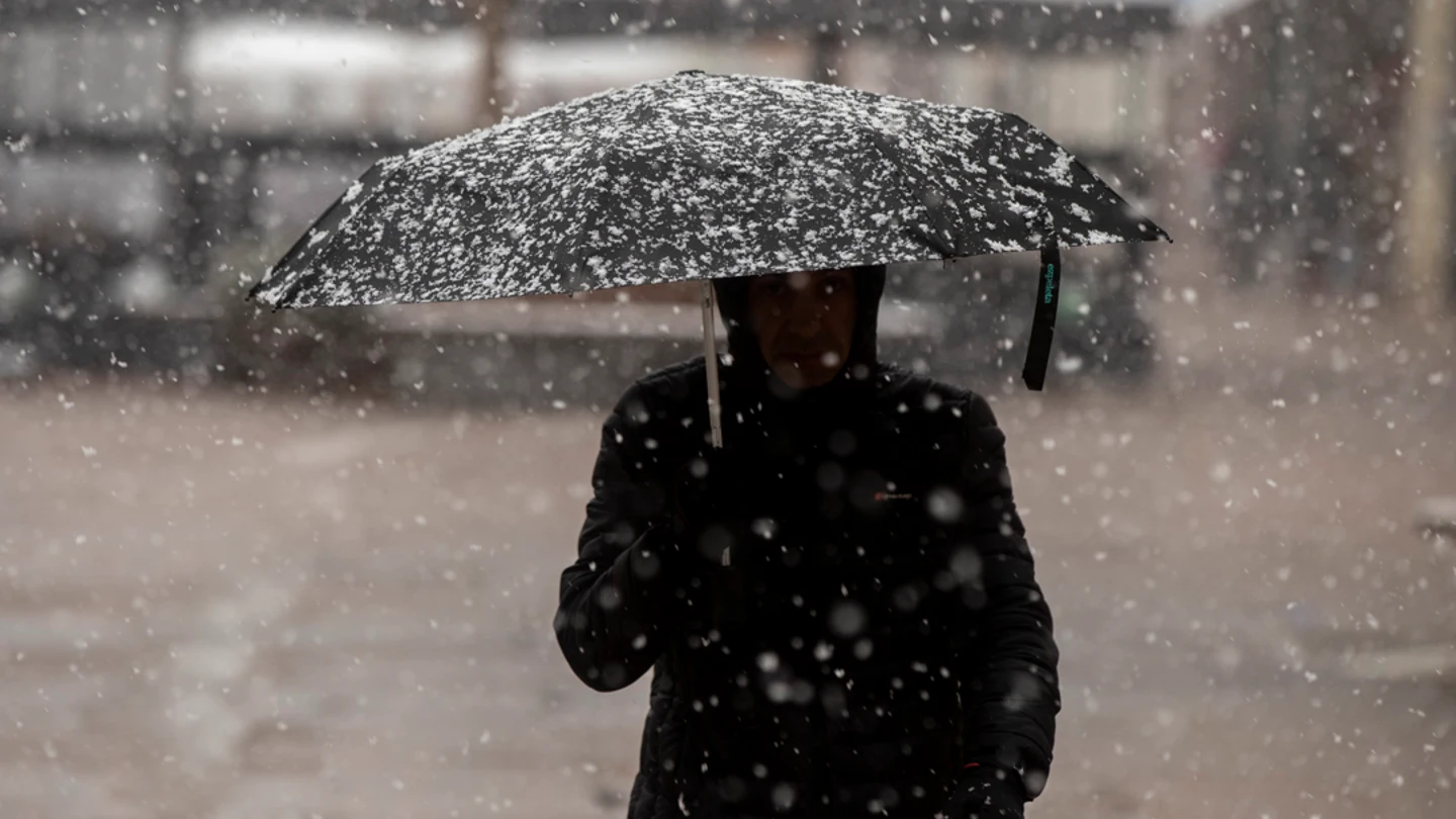 Un hombre se protege de la nieve en el centro de Vitoria Un hombre se protege de la nieve en el centro de Vitoria