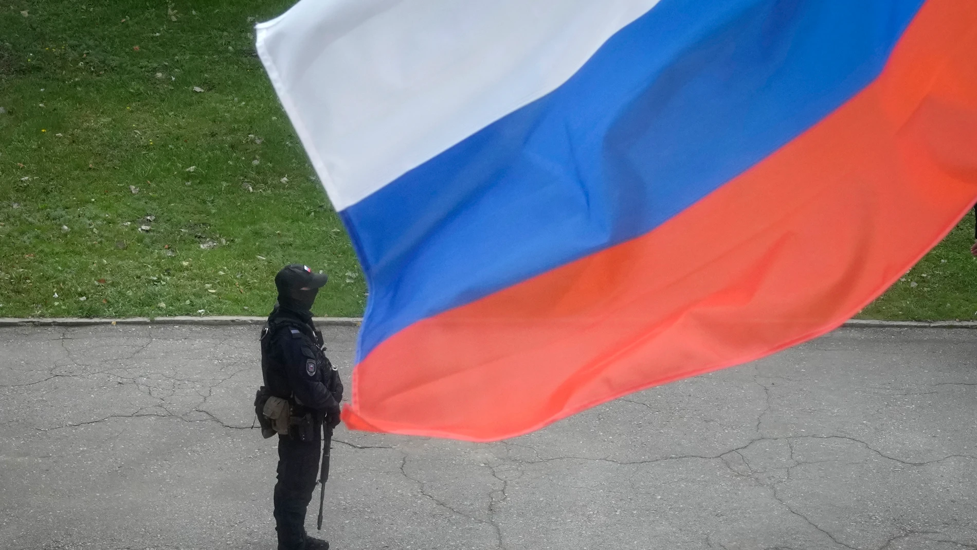 Un policía, junto a la bandera de Rusia