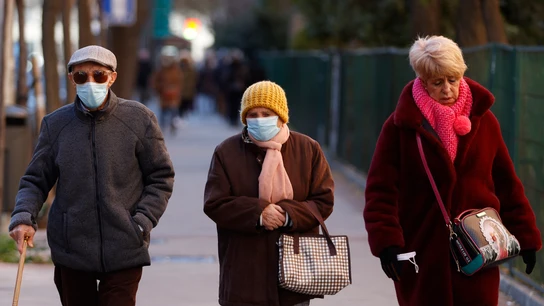 Tres personas pasean por las calles de Madrid Tres personas pasean por las calles de Madrid